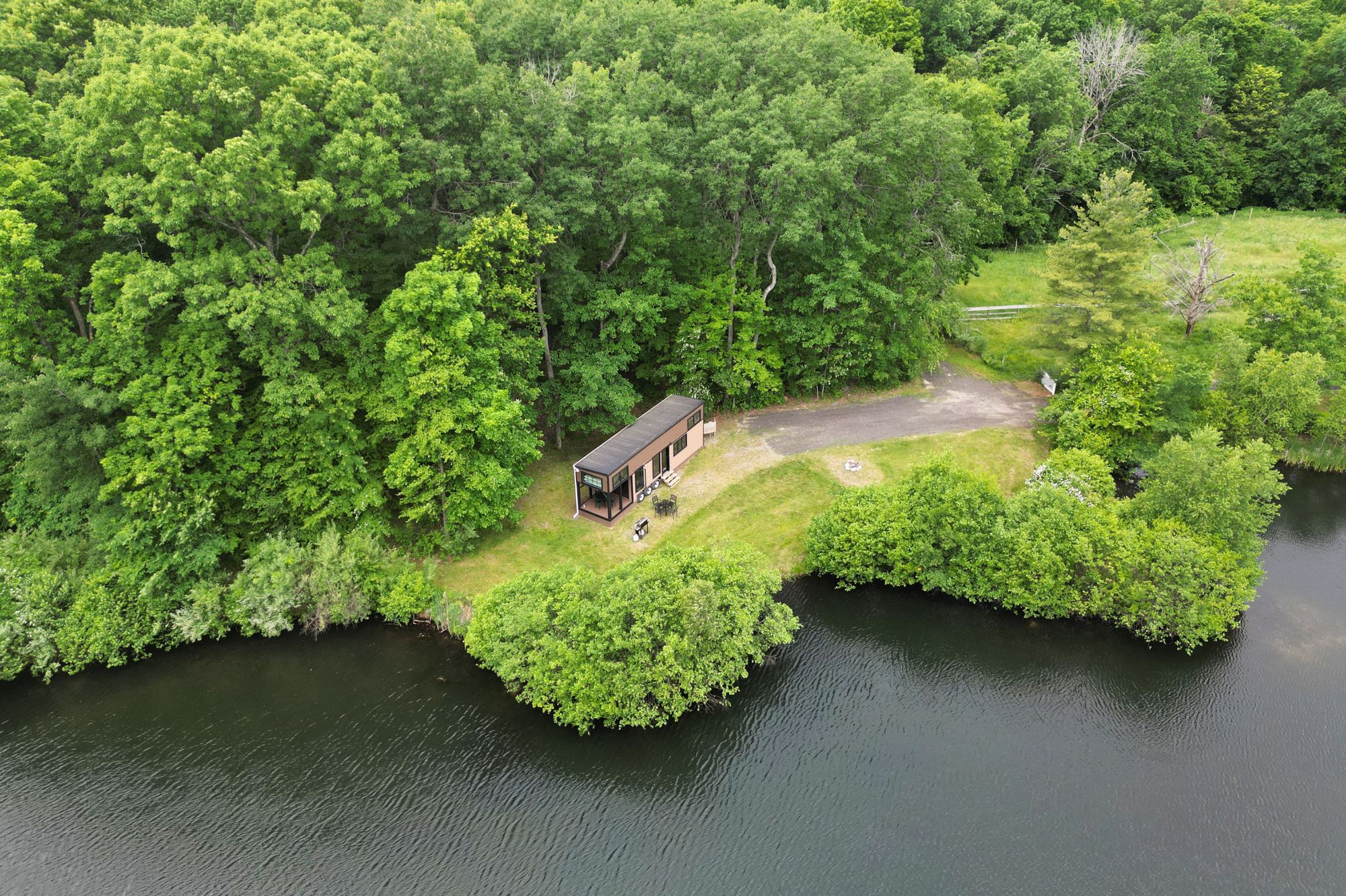 Tiny Home in the clearing under a blue sky
